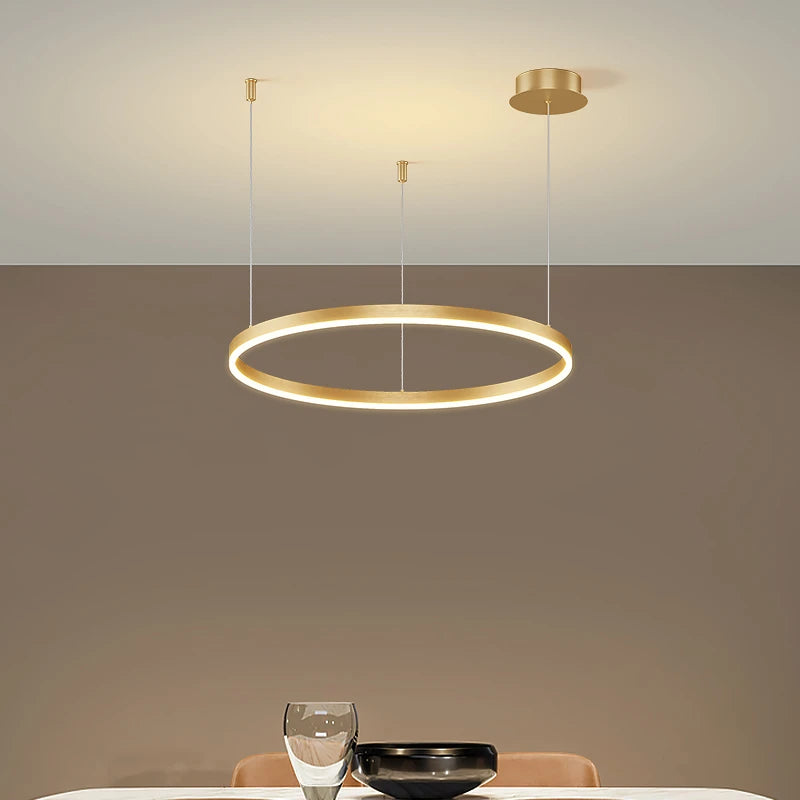 CIRCLETS single gold-finish LED ring, lit, above a dining table