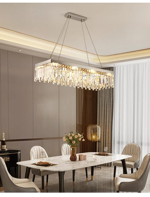 AMELIA rectangular crystal chandelier, lit, above a dining table