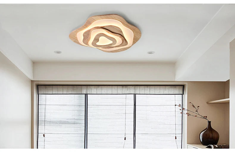 MAPLE layered wavy ceiling light in beige and wood tones, lit, in a room by a window