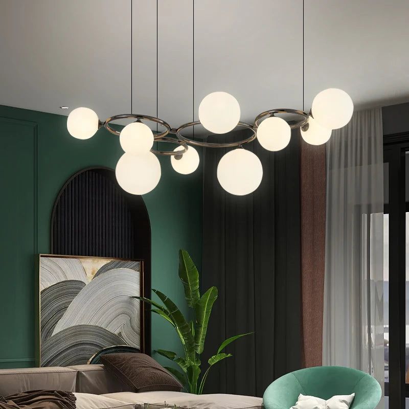 GLOBIQUE milk white glass globes on a dark ring frame, lit, in a green living room
