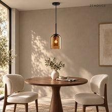 MAELLE Amber pendant above a compact round walnut dining table