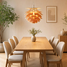 Plated brass SYLUNE chandelier isolated with layered pine-cone metal panels.