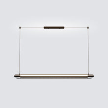 NOXVARE pendant suspended above a dark dining table in a warm wood-toned interior.