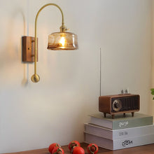 ARLETTE - Amber round glass wall sconce above a console