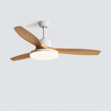 White SKAGEN ceiling fan with wood blades illuminating a calm, warm-toned bedroom.