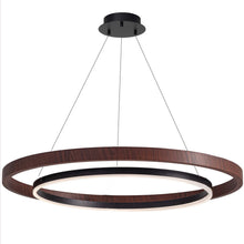 Shallow underside view of the walnut ORLUNEA rings suspended in a bright room.