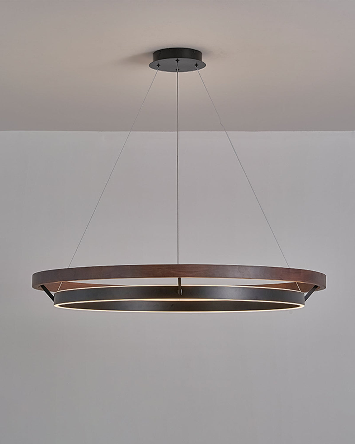 Close-up of ORLUNEA’s light wood grain, black ring, and fine suspension cable.
