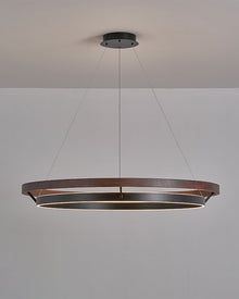 Close-up of ORLUNEA’s light wood grain, black ring, and fine suspension cable.