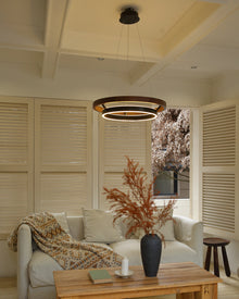 Walnut ORLUNEA chandelier suspended from a coffered ceiling above a pale sofa.