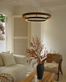 Wide walnut ORLUNEA chandelier above neutral seating in a bright shuttered room.