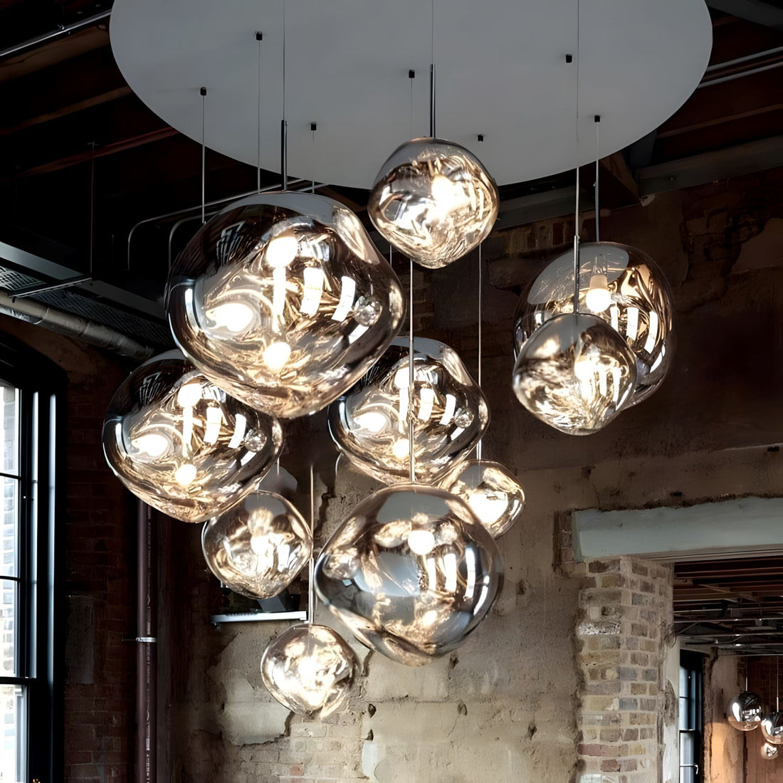 LAVA DROPS silver mirrored globes on a large round canopy in an industrial loft with brick walls