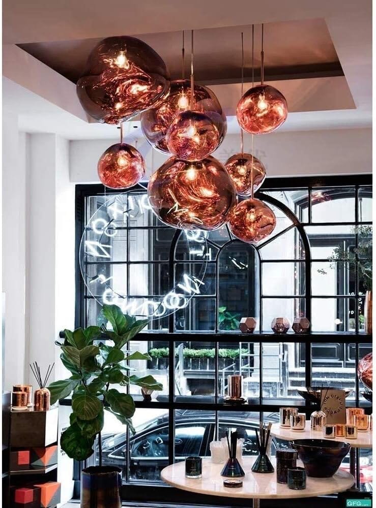 LAVA rose gold pendant cluster in front of a large arched café window