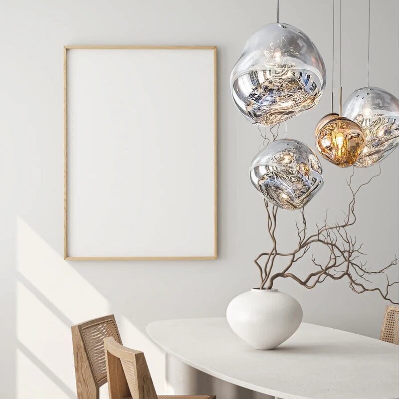 LAVA silver and gold pendants above a white dining table with a branch vase