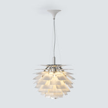 Copper SYLUNE pendant centered above a long light-wood dining table.