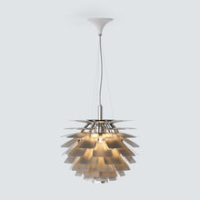 Copper-toned SYLUNE chandelier glowing above a cozy neutral living room.