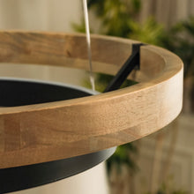 Large weathered-wood ORLUNEA chandelier showing broad concentric rings and warm light.