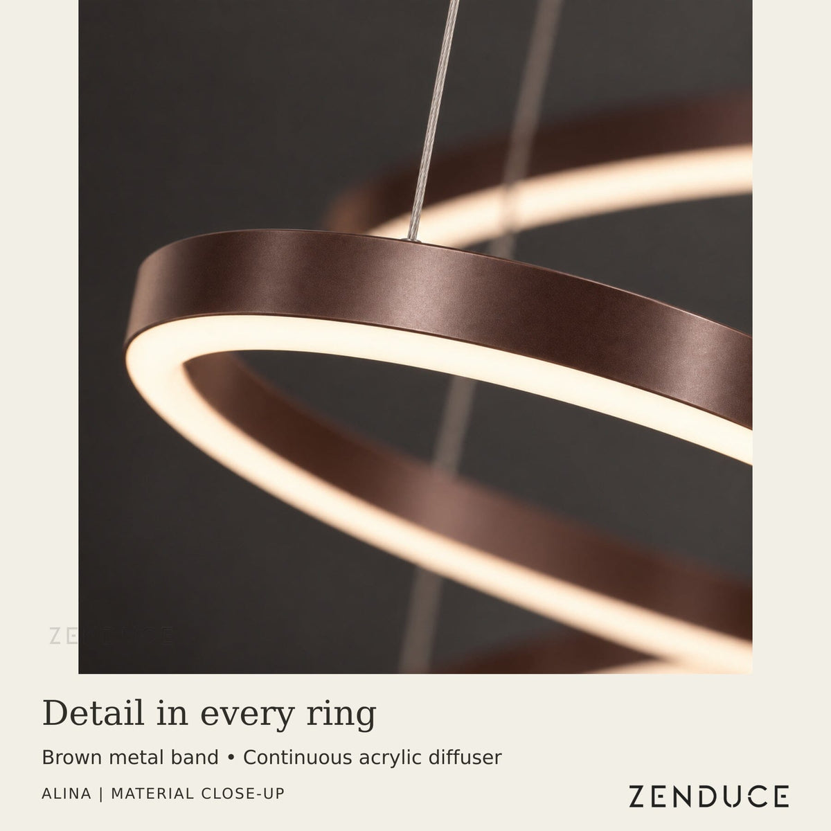 Close-up of ALINA Brown ring showing the metal band, illuminated acrylic underside diffuser and fine suspension cable.