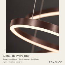 Close-up of ALINA Brown ring showing the metal band, illuminated acrylic underside diffuser and fine suspension cable.