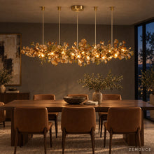 ALUNA Linear Coffee glass chandelier illuminating a dining room at dusk