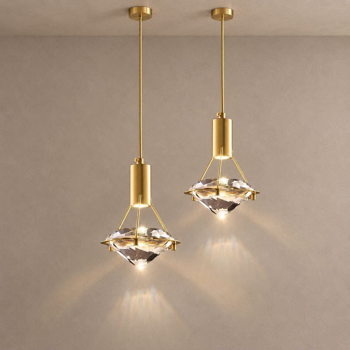 ANTHEIA gold and faceted crystal pendants against mushroom taupe plaster with natural shadows