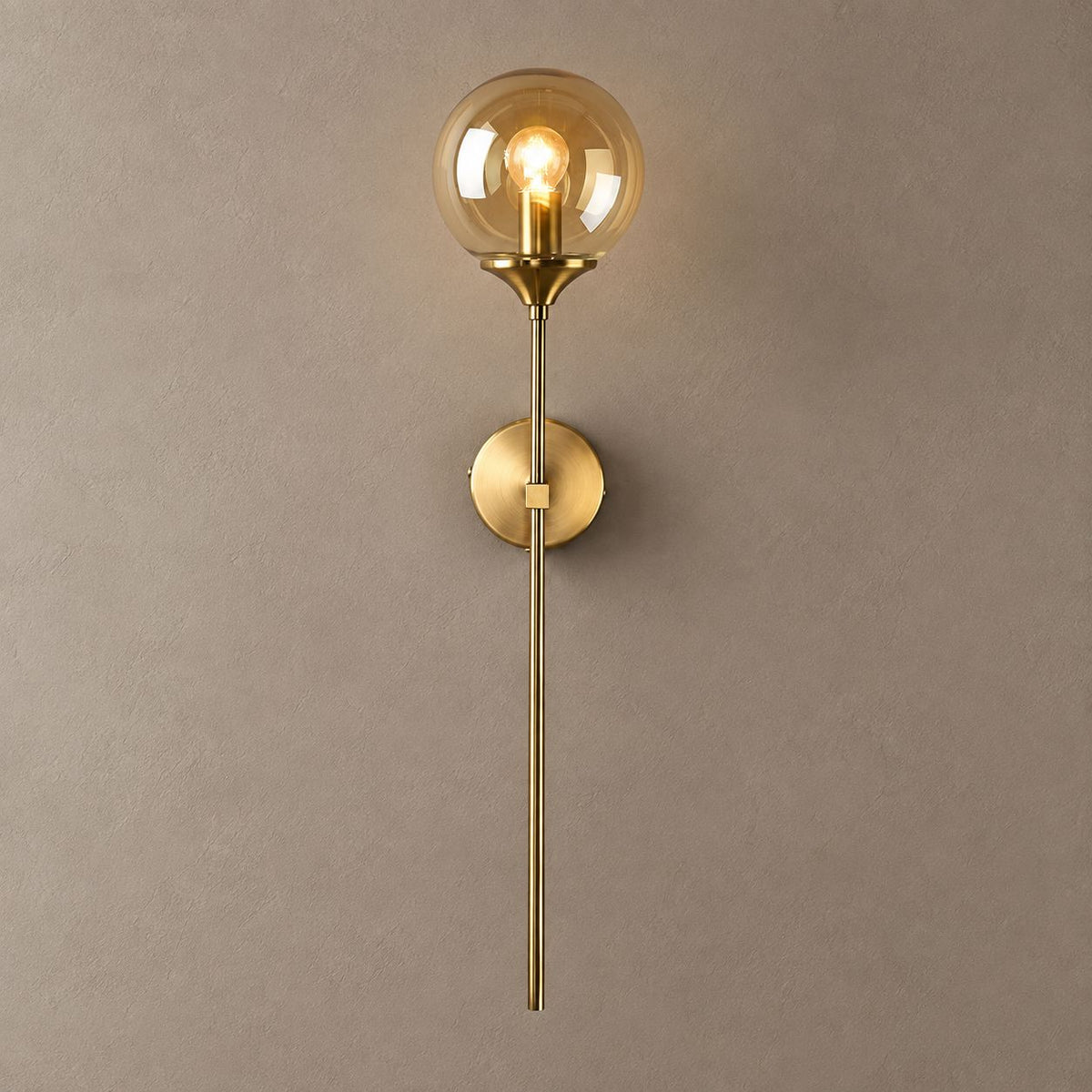 BEACON brass wall sconce with amber glass globe and long stem on mushroom taupe plaster