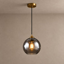BETHANIE smoky glass globe pendant with brass canopy and warm filament bulb on mushroom taupe plaster