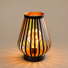 BRYSSA black and gold metal cordless lantern on a mushroom taupe background