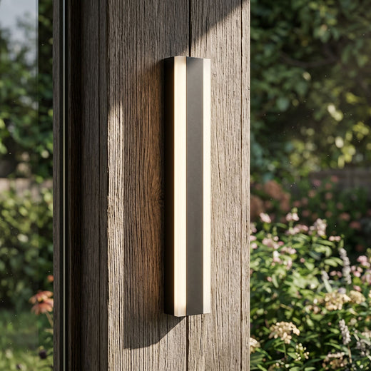 Detailed close-up of Bolt wall light on wooden panel in garden, showcasing materials, frosted finish, and subtle lighting details.