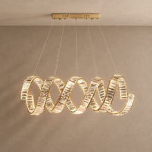 CODON gold-finish linear chandelier with a twisting crystal ribbon, lit