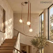 CORIA three-light chandelier with red-brown leather straps and opal glass globes in a real staircase setting