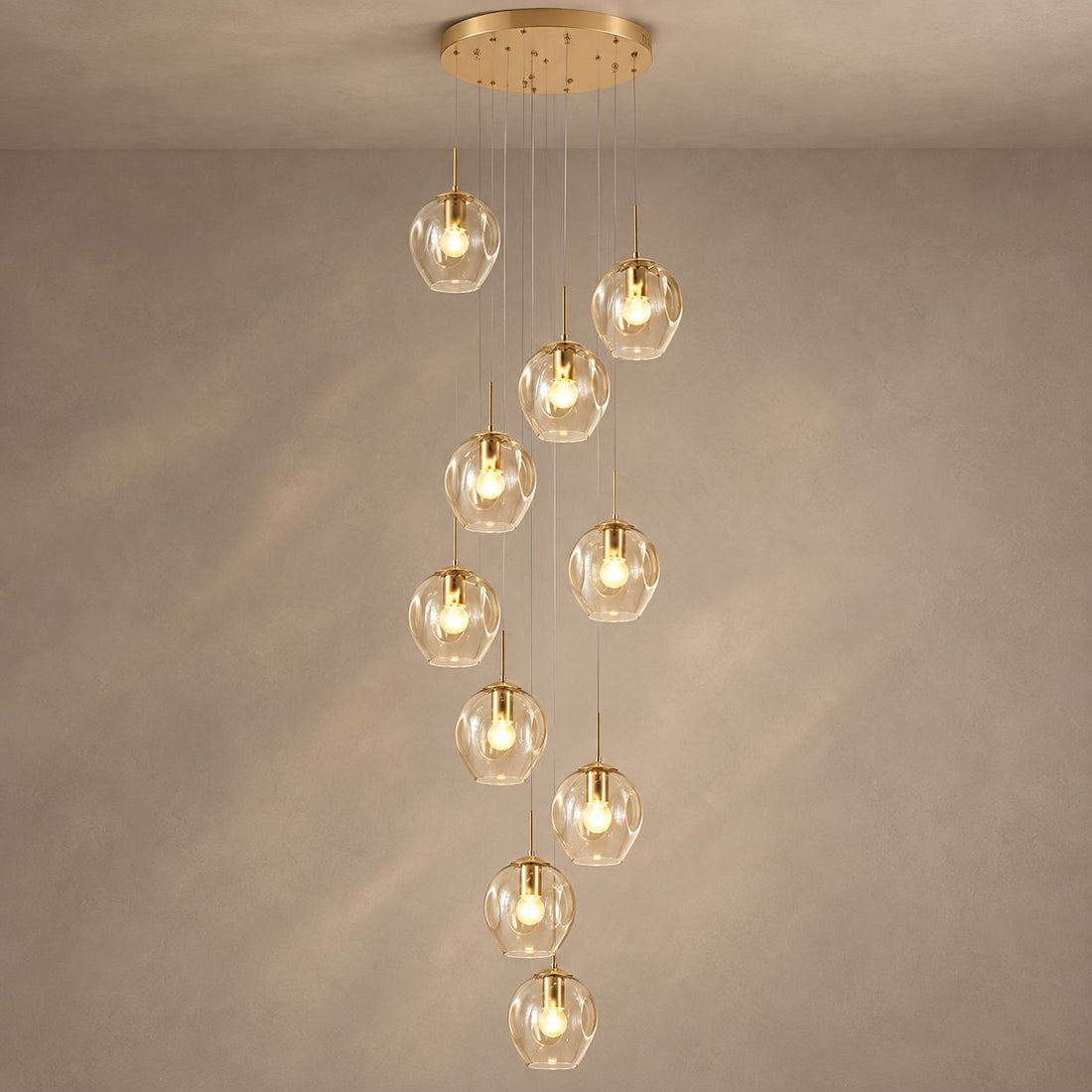 ELIOS cascading chandelier with ten champagne glass globes and gold fittings on mushroom taupe plaster