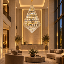 SERAPHINE gold tiered chandelier in a limestone hotel lobby