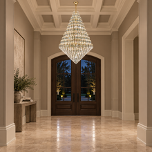 SERAPHINE gold chandelier in a high-ceiling entryway with timber doors