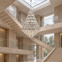 SERAPHINE chrome chandelier in a large multi-level stone staircase