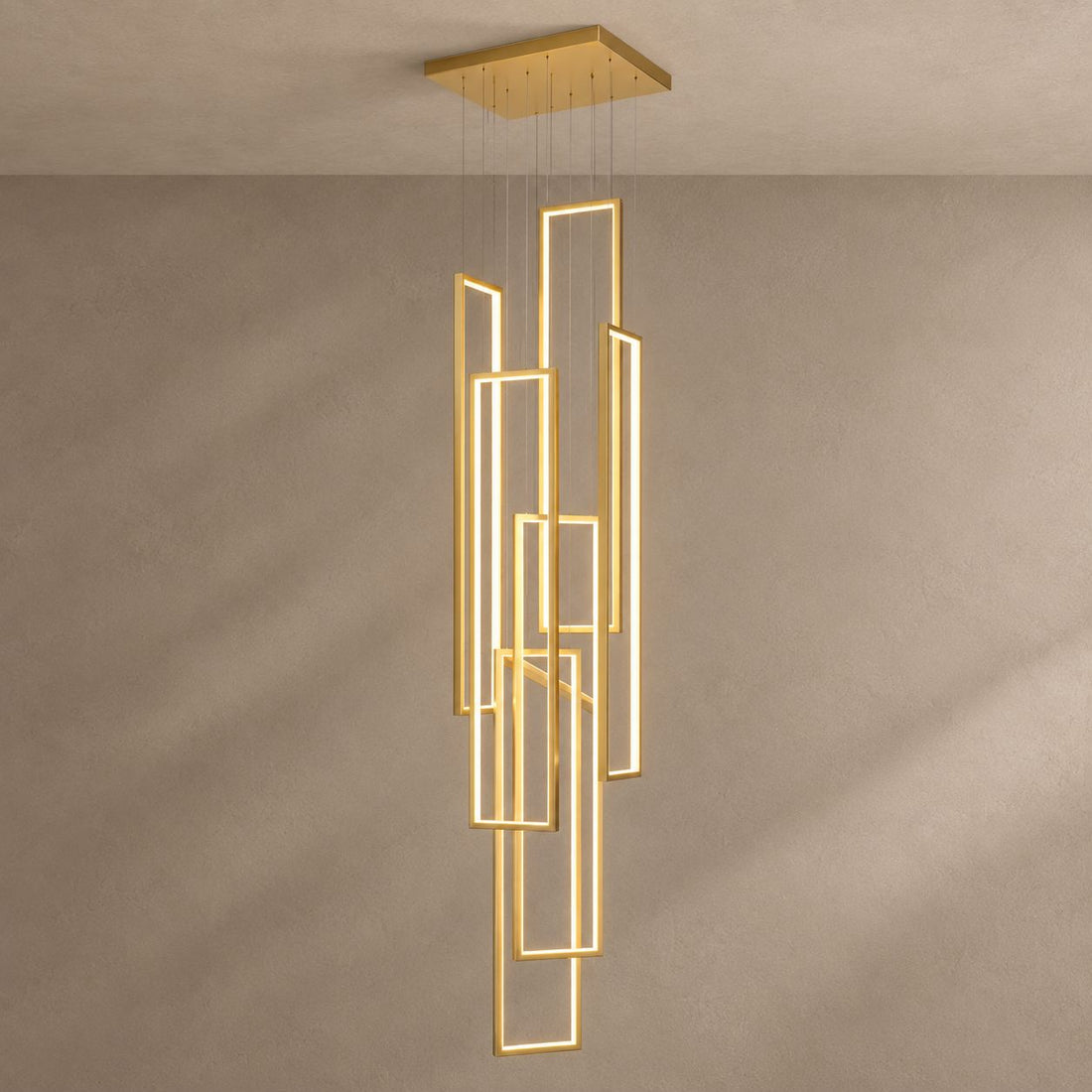 FRAMES gold chandelier with six staggered rectangular LED frames against mushroom taupe plaster