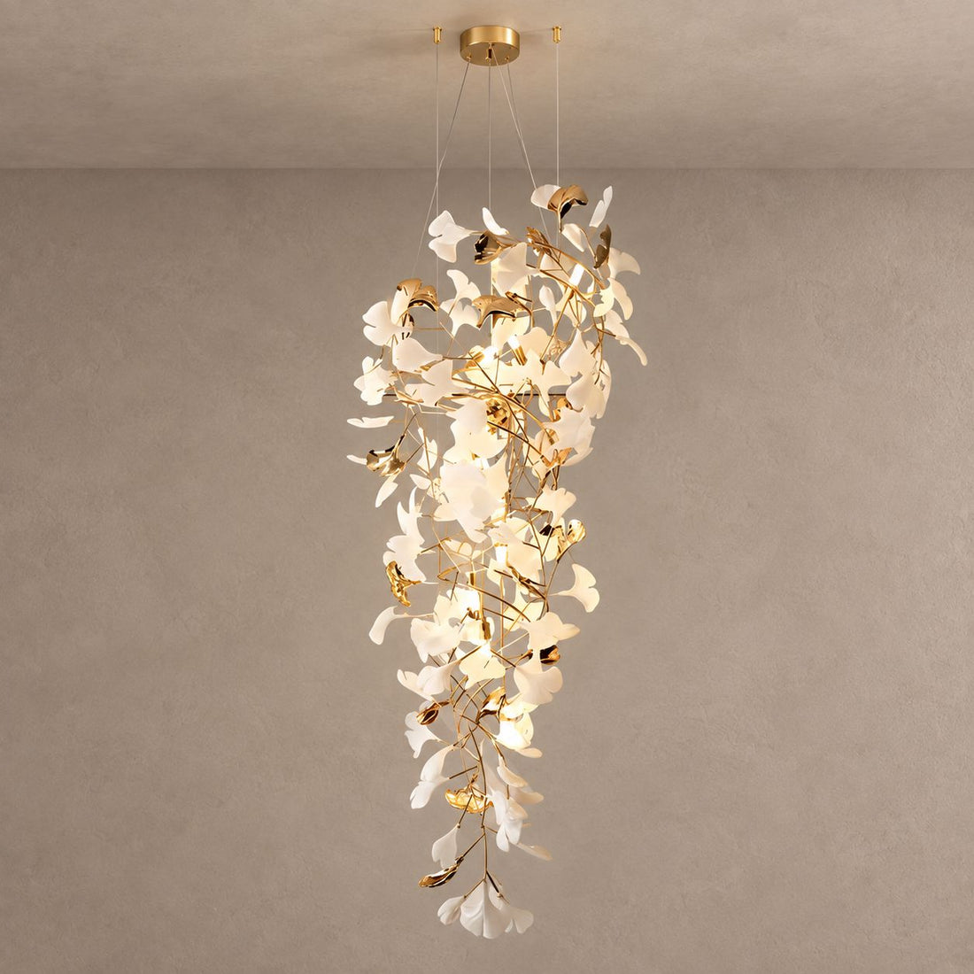 GINGKO GRAND cascading gold and white ceramic leaf chandelier on mushroom taupe plaster with natural shadows