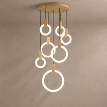 HALO seven-ring willow wood chandelier with luminous white rings on a mushroom taupe plaster background