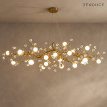 NESSA Gold linear crystal branch chandelier against a warm taupe background