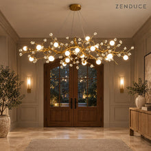 NESSA Gold chandelier illuminating a taupe entrance hall with wood double doors
