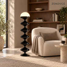 NOLIA black floor lamp visualized beside an ivory armchair and walnut shelves