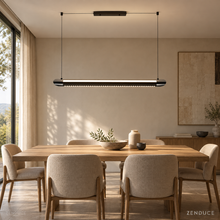 NOXVARE glossy black linear LED pendant above an oak dining table in a sunlit cream interior