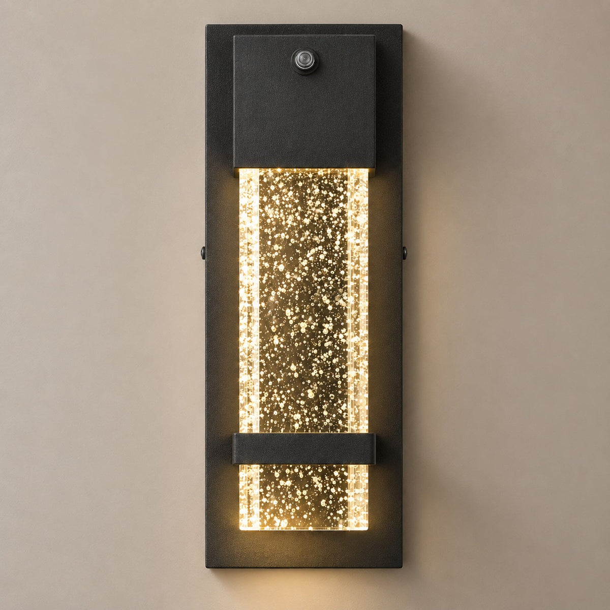NUVIEL Dusk to Dawn Sensor wall light on mushroom taupe with natural shadow: small photocell, black aluminum backplate and clear illuminated bubble glass.