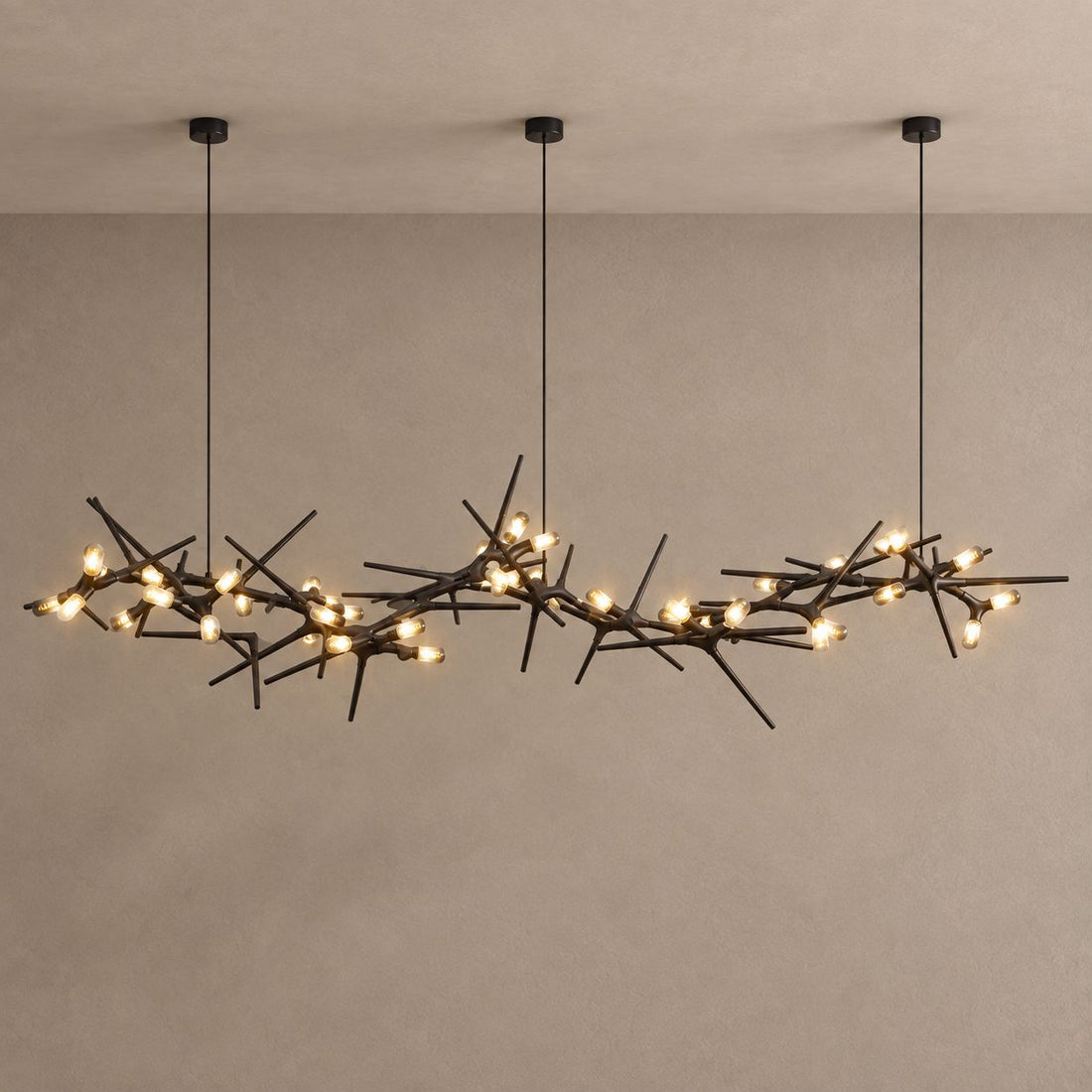 ONYX black branching chandelier with warm capsule lights against mushroom taupe plaster and natural ceiling shadows