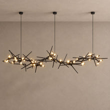 ONYX black branching chandelier with warm capsule lights against mushroom taupe plaster and natural ceiling shadows
