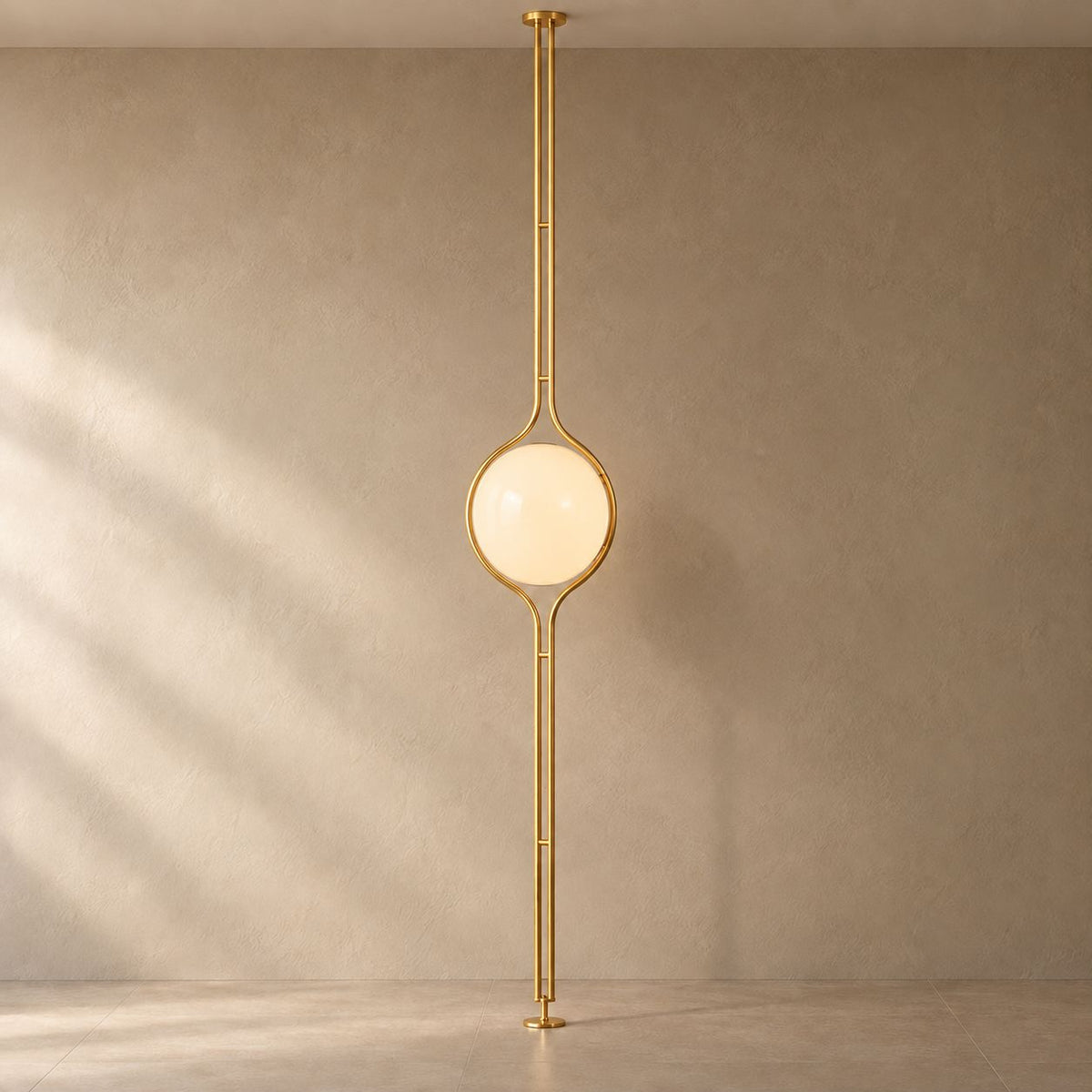 ORELIA Brass floor-to-ceiling globe lamp on a mushroom taupe background