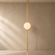 ORELIA Brass floor-to-ceiling globe lamp on a mushroom taupe background