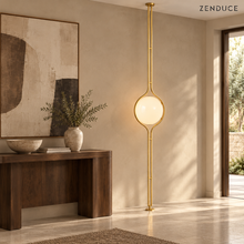ORELIA Brass lamp beside a walnut console in a limestone-floored entryway