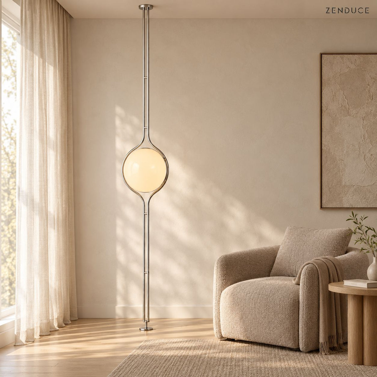 ORELIA silver globe lamp beside a taupe armchair in a sunlit reading corner