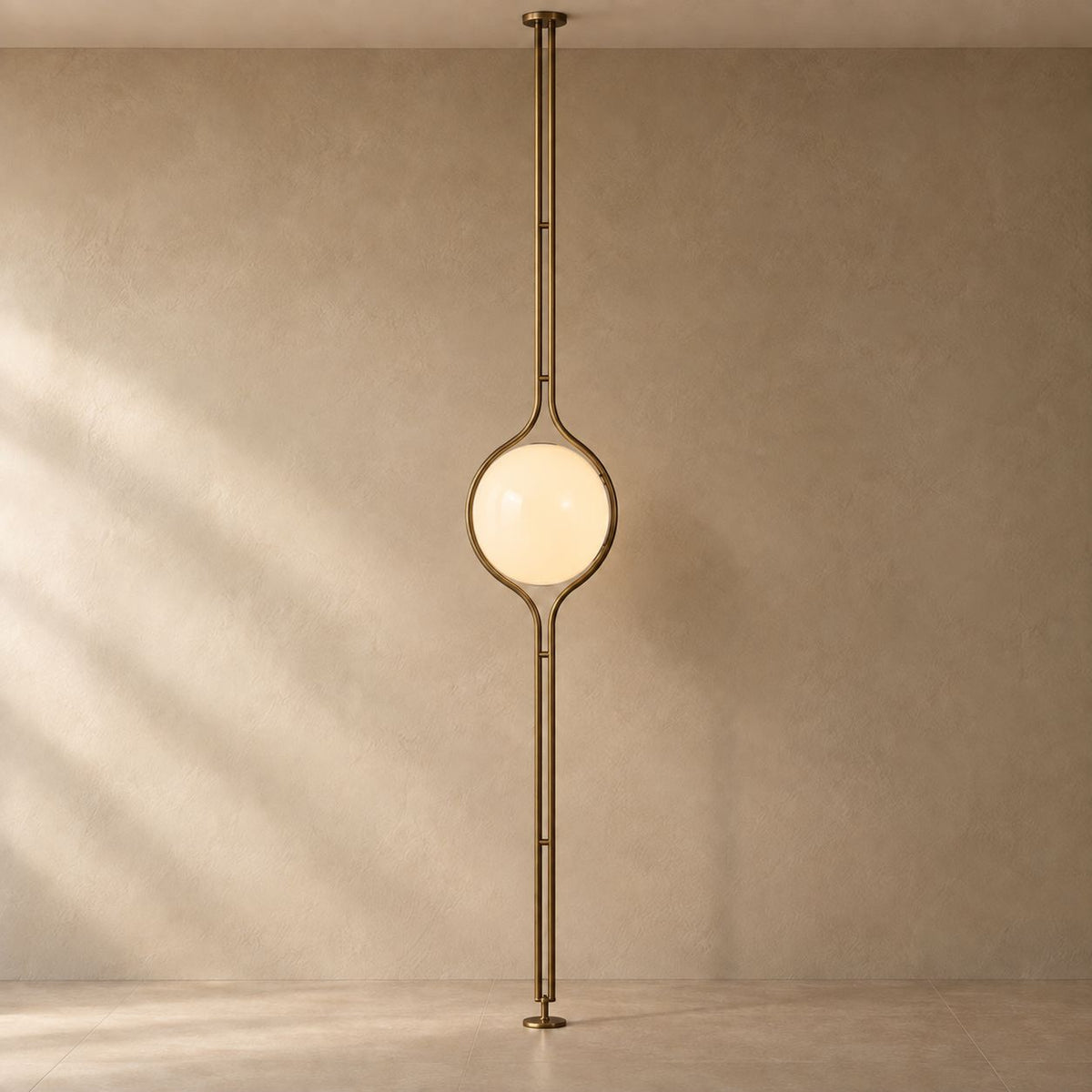 ORELIA Vintage Brass floor-to-ceiling globe lamp with natural floor and wall shadows