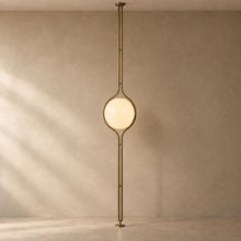 ORELIA Vintage Brass floor-to-ceiling globe lamp with natural floor and wall shadows